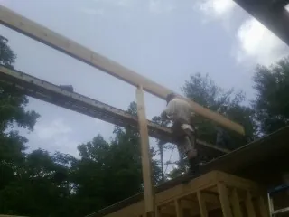 Carpenter setting a ridge beam over a new addition frame — Ice Dam Removal by Roofing Brothers in Mahopac Falls