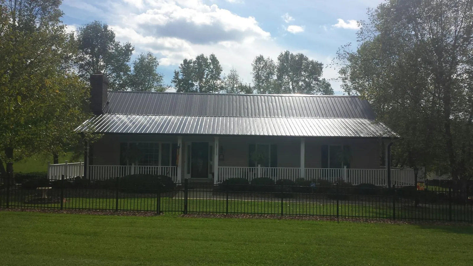 Gray metal roof on a brick ranch with a full width front porch — Gutter Guard Installation work by our crew in Mahopac Falls