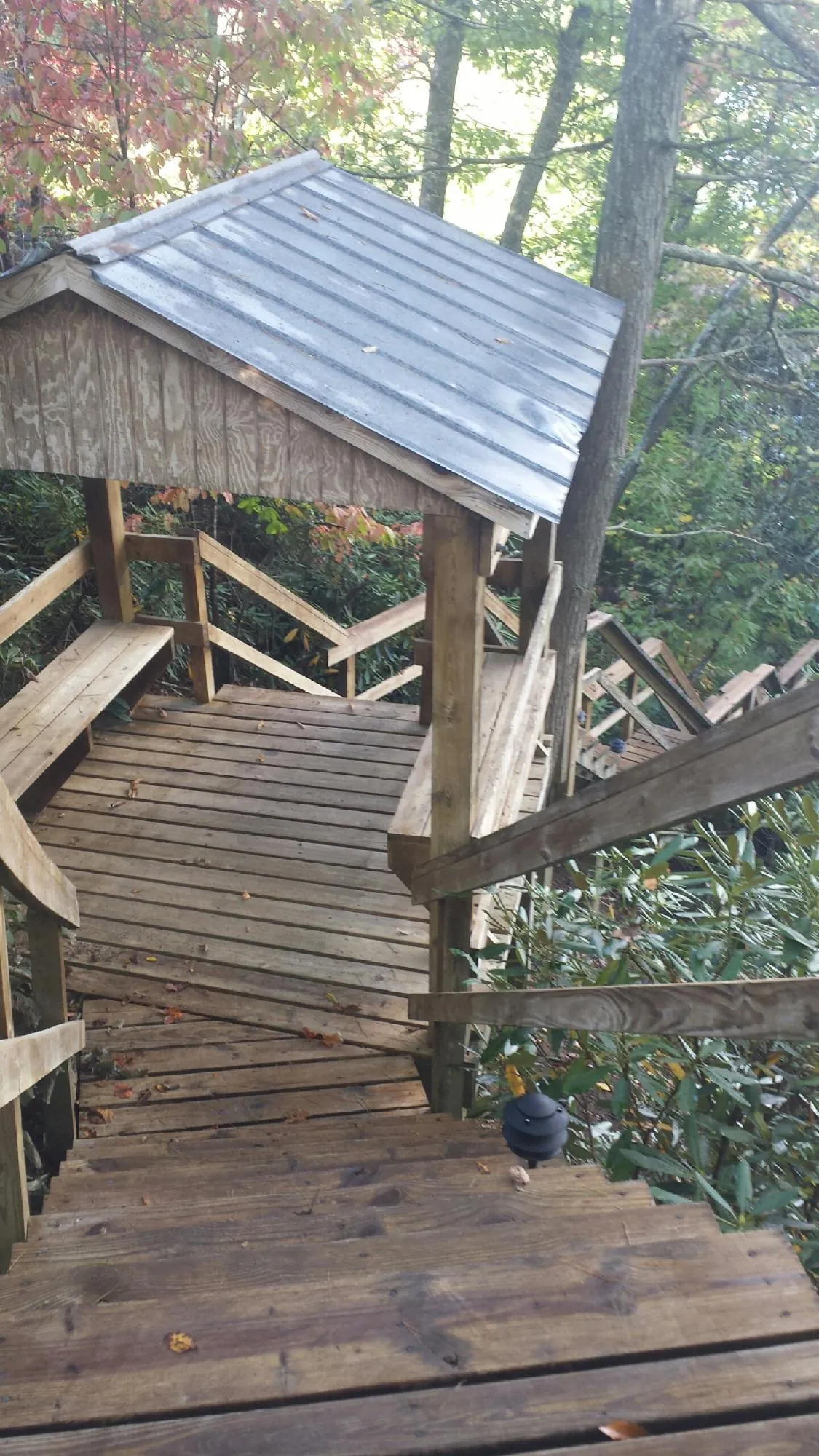 Metal roofed shelter over wooden steps on a wooded walkway — Skylight Repair & Installation work by our crew in Mahopac Falls